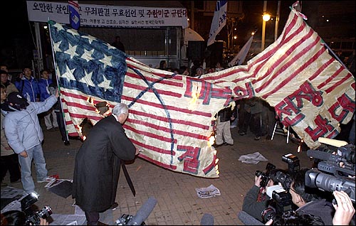 범국민 대책위 대표자가 대형 성조기를 태우고 있다. 경찰은 이전과 달리 성조기 화형식을 직접 저지하지는 않았다. 